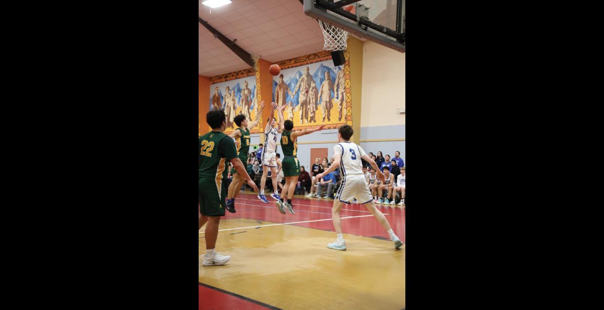 Photo by Anna Lionas THREE POINTS- Cohen Booth attempts a three point shot while the Seahawks try to block it.