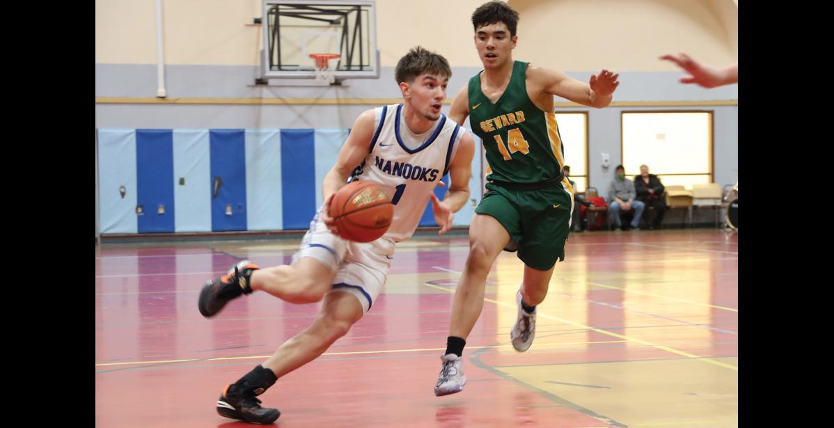 Photo by Anna Lionas DRIBBLING- Nanook Finn Gregg dribbles around Seahawk Ben Ambrosiani.