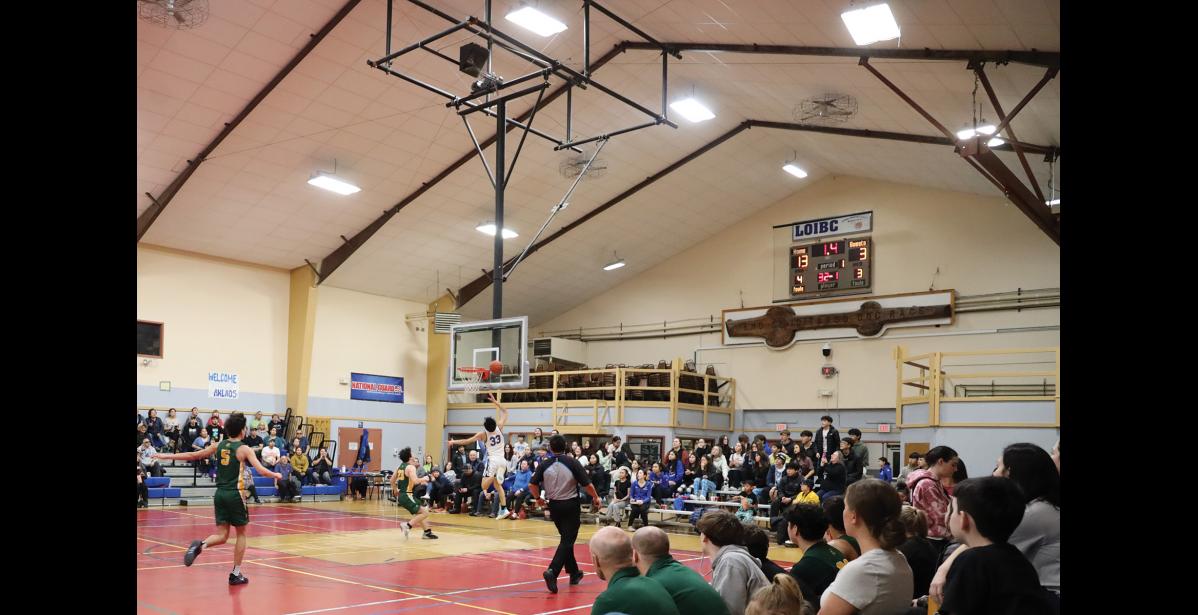 Photo by Anna Lionas ACROSS THE COURT- Richard Cross races across the court to make a buzzer-beating layup.