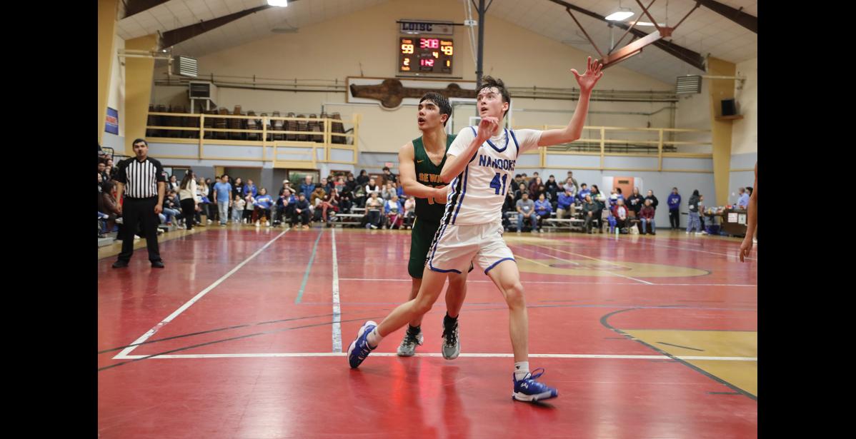 Photo by Anna Lionas OVER HERE! - Cohen Booth reaches up to catch a pass while being guarded by Nick Ambrosiani of Seward.