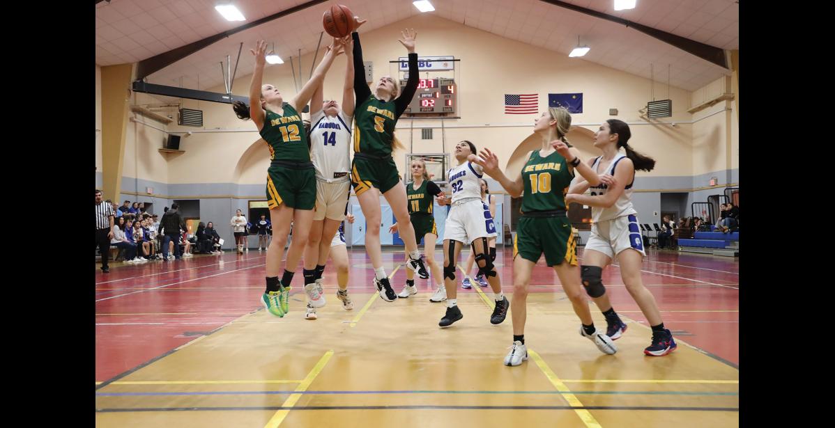 Photo by Anna Lionas REACHING- Seahawk Mikinley Williams, Nanook Benny Lie and Seahawk Robin Cronin all jump to get a rebound while their teammates look on.
