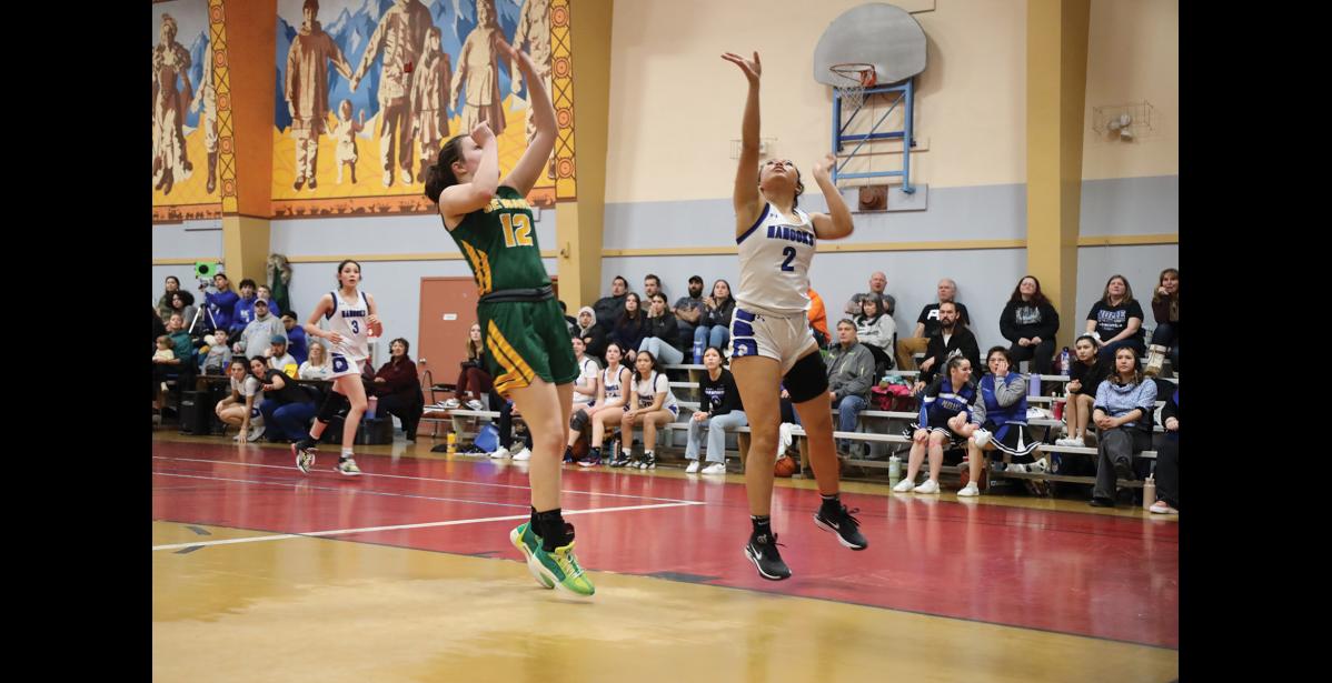 Photo by Anna Lionas PUT IT UP-Nanook Jocelyn Nichols-Takak takes a shot while Seahawk Mikinley Williams goes for the rebound.