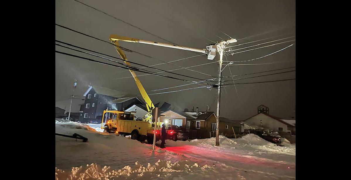 Photo by John Handeland WORKING THROUGH THE STORM— A NJUS line crew is fixing a power outage near Steadman St. during the Dec. 28 storm.
