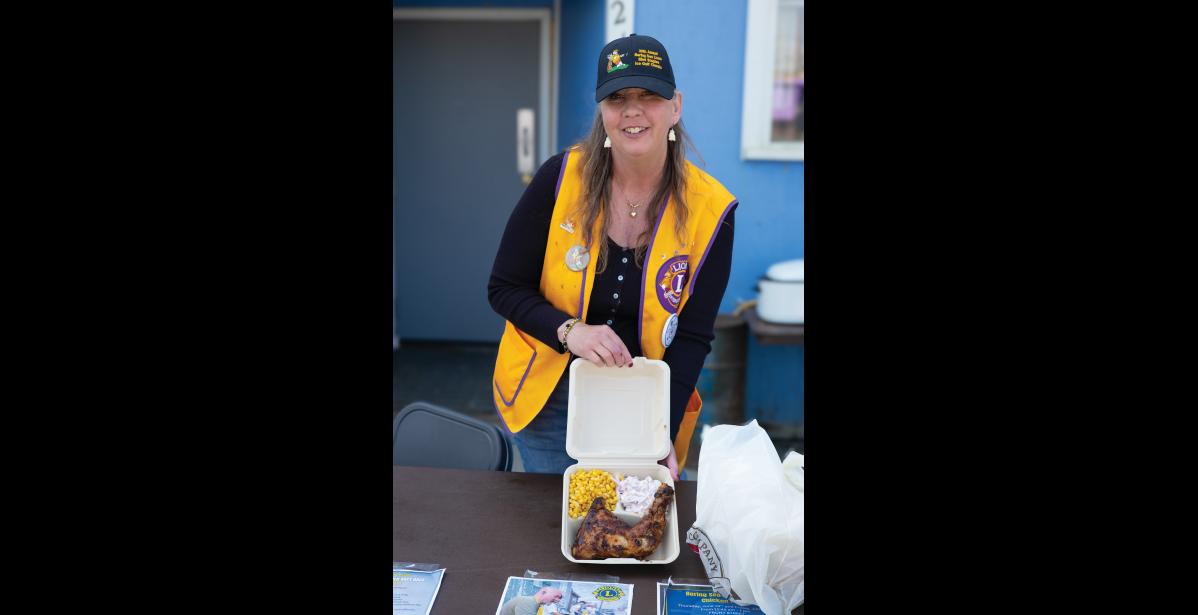 Photo by Nils Hahn Pam Cushman with the Bering Sea Lions Club served delicious chicken at the Chicken Feed.