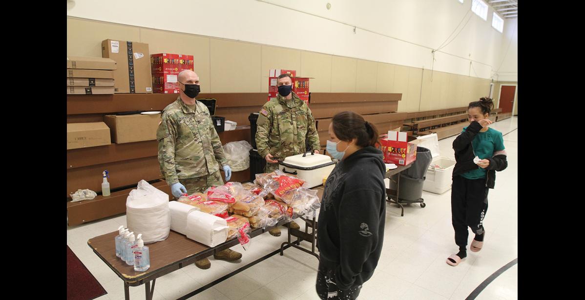 Photo by Peter Loewi PUBLIC OUTREACH— Sgt. 1st Class Kempner and Sgt. Conant greet Nome residents with hamburgers and hotdogs fresh off the grill during an outreach event at the National Guard Armory on Sunday, Feb. 27, as part of the Arctic Eagle exercise in Nome.