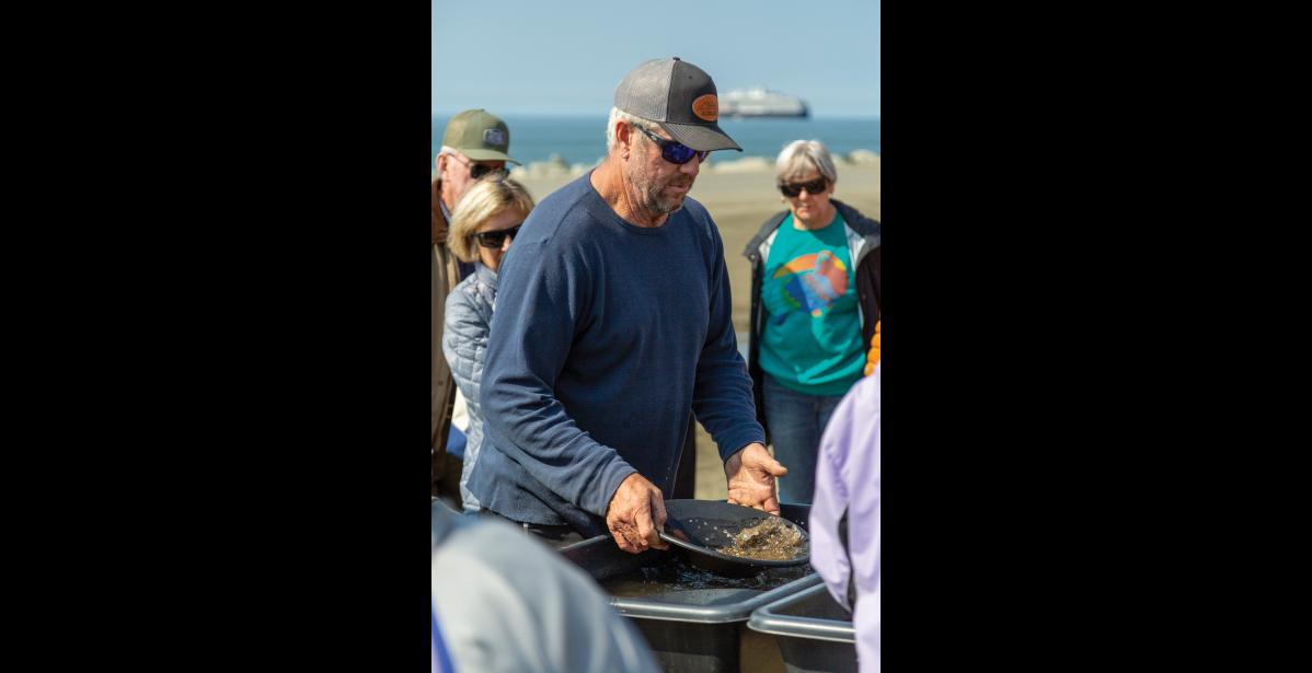 Photo by Sarah Manriquez GOLD EXPERT— Augie Krutzsch of AKAU Alaska Gold & Resort demonstrates gold panning to Westerdam cruise passengers on Thursday, June 19, 2025. He and his wife, Carrie Hines, set up gold panning stations for guests to try the technique firsthand.