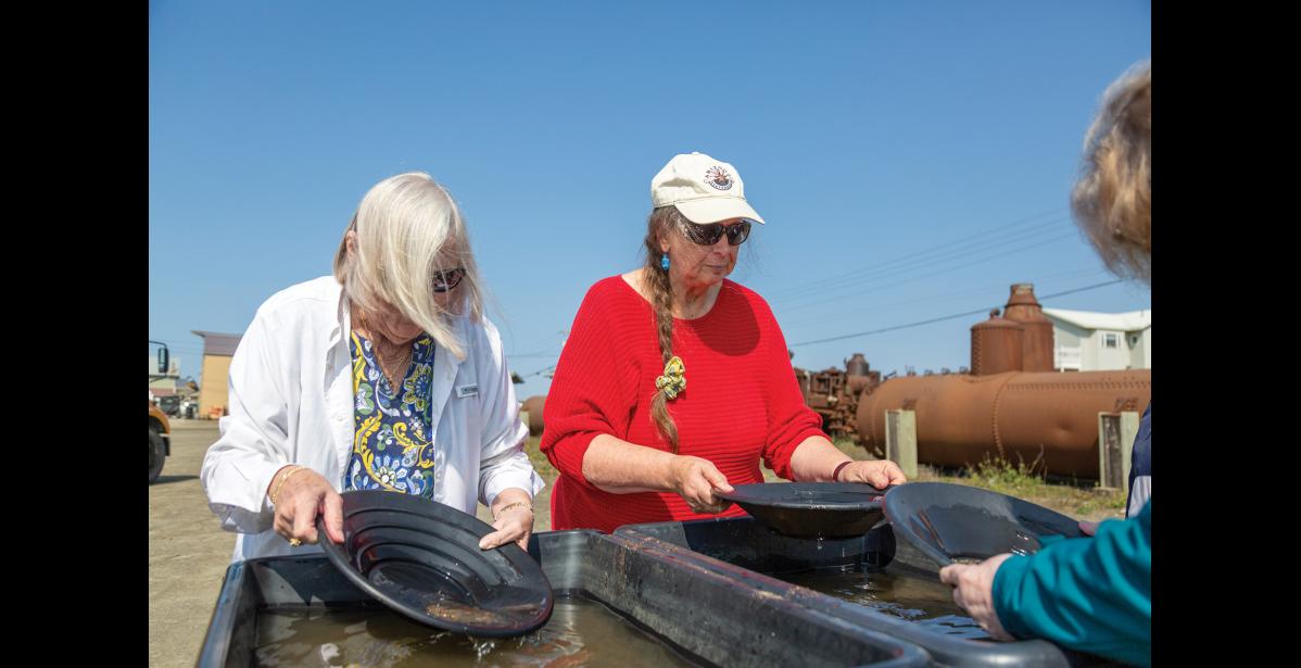 Photo by Sarah Manriquez GOLD PANNING— Westerdam cruise passengers Ann Uhde of Florida, left, and Joy Stoltzmann of Arizona, right, try their hand at gold panning while ashore in Nome on Thursday, June 19, 2025. For both visitors, it was their first time in Nome. Stoltzmann, a fan of the TV show Bering Sea Gold, said she had hoped to spot cast members while in town.