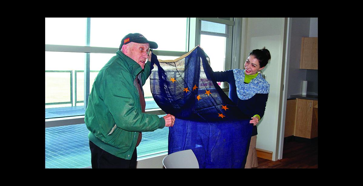 Photo by Sandra L. Medearis FIELD OF BLUE—Mayor Richard Beneville and Director Amy Phillips-Chan of Carrie M. McLain Memorial Museum show an antique Alaska flag that Beneville brought to the April 20 meeting of the Nome Museum and Library Commission.