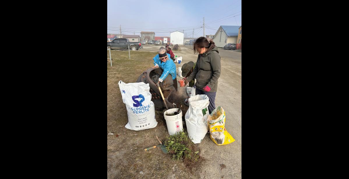 HARD AT WORK— Cheryl Thompson and Kim Knudsen readying a dredge bucket for flowers. Photo courtesy Angela Hansen