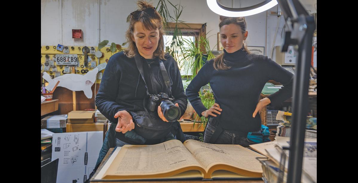 IN THE ARCHIVES – Aurélie Pollet and Gabrielle Dembinski read the August 3, 1929 edition of the Nome Nugget Newspaper inside the Nugget office on Friday, July 3. Photo by Ariana Crockett O’Harra