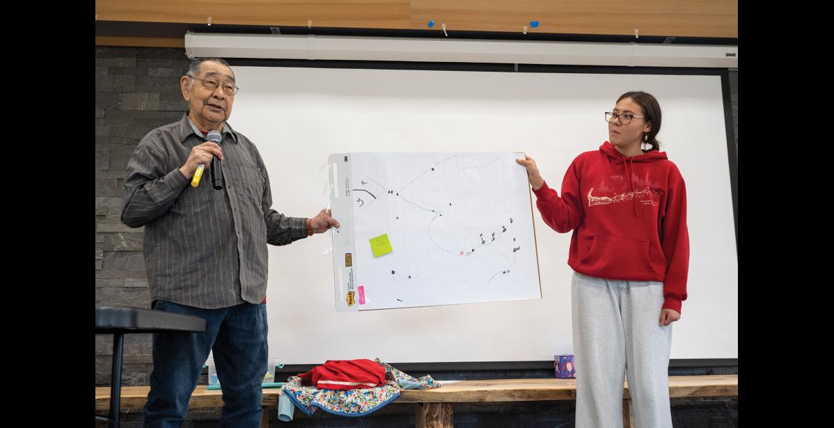 HISTORY— Richard Atuk and ANSEP Acceleration Academy student Clary Ruud hold a chart detailing the history of the region during the Inupiaraaqta workshop on Thursday, September 10 at the King Island Native Community Hall. Photo by Ariana Crockett O'Harra