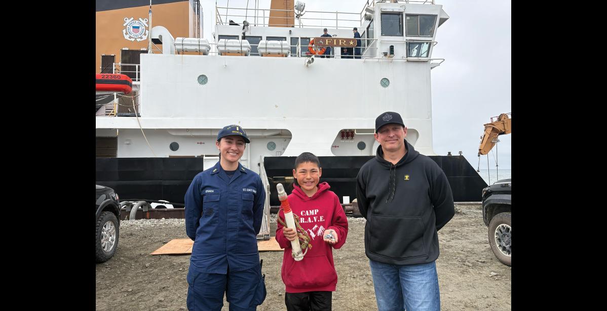 Adrian White, holding a strobe beacon and challenge coin, poses with Ensign Jaelyn O’Hara and Lieutenant Commander Ryan Foust of the U.S. Coast Guard buoy tender Fir on July 31. Photo courtesy of Angie Nguyen