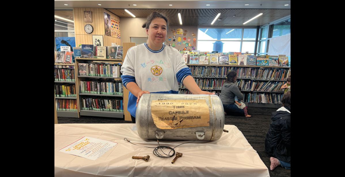 Photo by Diana Haecker TIME CAPSULE— Library Assistant Janet Steppe holds the 1990 Time Capsule, which will be opened on July 17 at the Kegoayah Kozga Library.