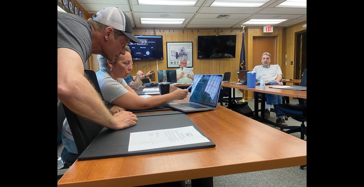 Photo by Diana Haecker MINING PERMIT— Councilwoman Jennifer Reader confirms with Shawn Pomrenke of Northwest Gold Diggers where he plans to mine for gold within the Moonlight Wells Protective area, during Tuesday’s Nome Common Council meeting.