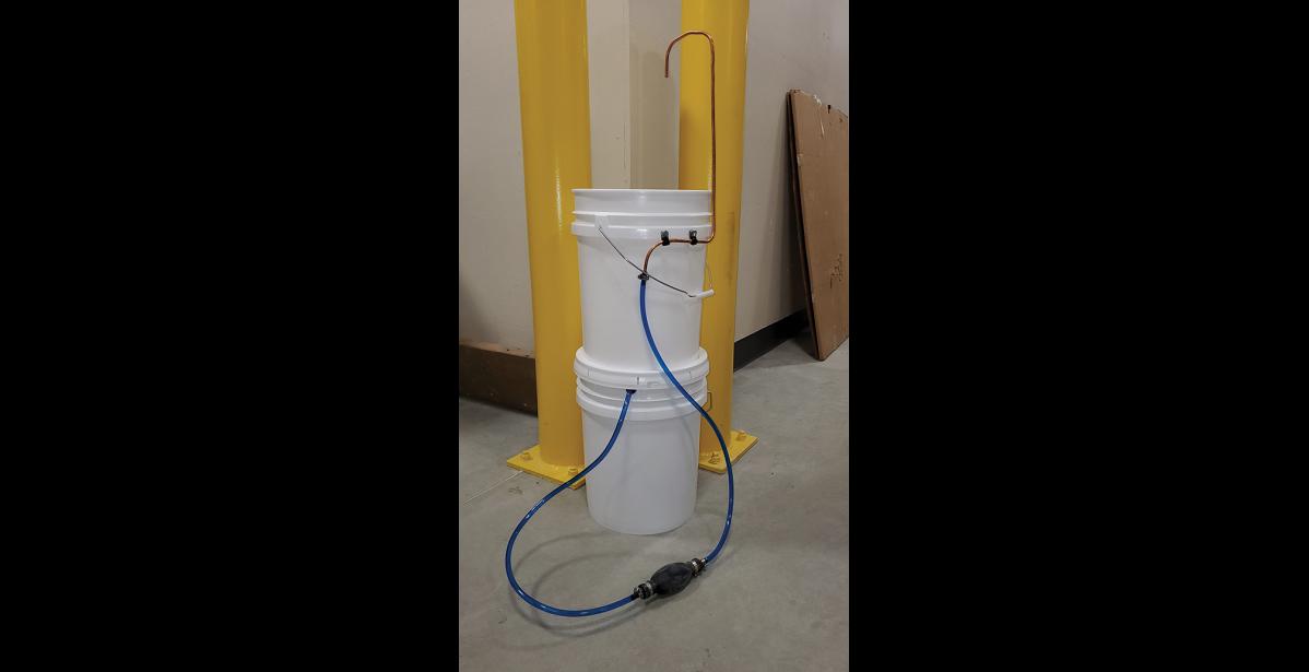 Photo by Sean Lee LOW TECH SOLUTION— A handwashing station made out of two five-gallon buckets, a foot pump and a copper spigot allows for relatively easy handwashing in places without running water and sewer.
