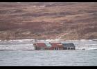 Photo by Jim Dory CABIN ADRIFT – Rita Hukill’s cabin drifts in the Nome River after it was swept off the sandspit at Fort Davis.