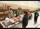 Photo by Peter Loewi PUBLIC OUTREACH— Sgt. 1st Class Kempner and Sgt. Conant greet Nome residents with hamburgers and hotdogs fresh off the grill during an outreach event at the National Guard Armory on Sunday, Feb. 27, as part of the Arctic Eagle exercise in Nome.