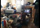 Photo courtesy Sue Steinacher NOWHERE TO GO— Two children sit on the floor of their living room in 2018. Two people sleep on the living room floor of this one-bedroom house in Savoonga, three sleep in the bedroom, and four sleep in the former kitchen.