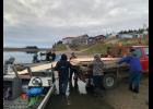 HANDOFF—The transport crew loads planks of plywood from a riverboat into the bed of a truck in White Mountain. The materials were driven from Nome to Council on the road, and then taken by boat to White Mountain.