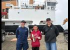 Adrian White, holding a strobe beacon and challenge coin, poses with Ensign Jaelyn O’Hara and Lieutenant Commander Ryan Foust of the U.S. Coast Guard buoy tender Fir on July 31. Photo courtesy of Angie Nguyen