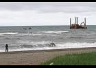 Photo by Diana Haecker TO THE RESCUE— A cameraman documents the incident as the War Pony skiff bobs in the sea, two skiffs stand by and the jackup rig begins to hoist the platform out of the stormy sea, on Tuesday afternoon.